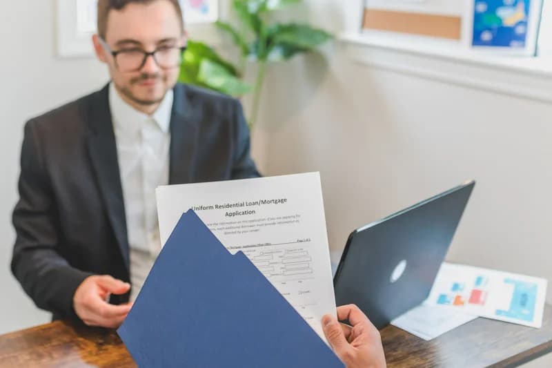 Graduate reviewing offers from student loan refinance companies at a desk